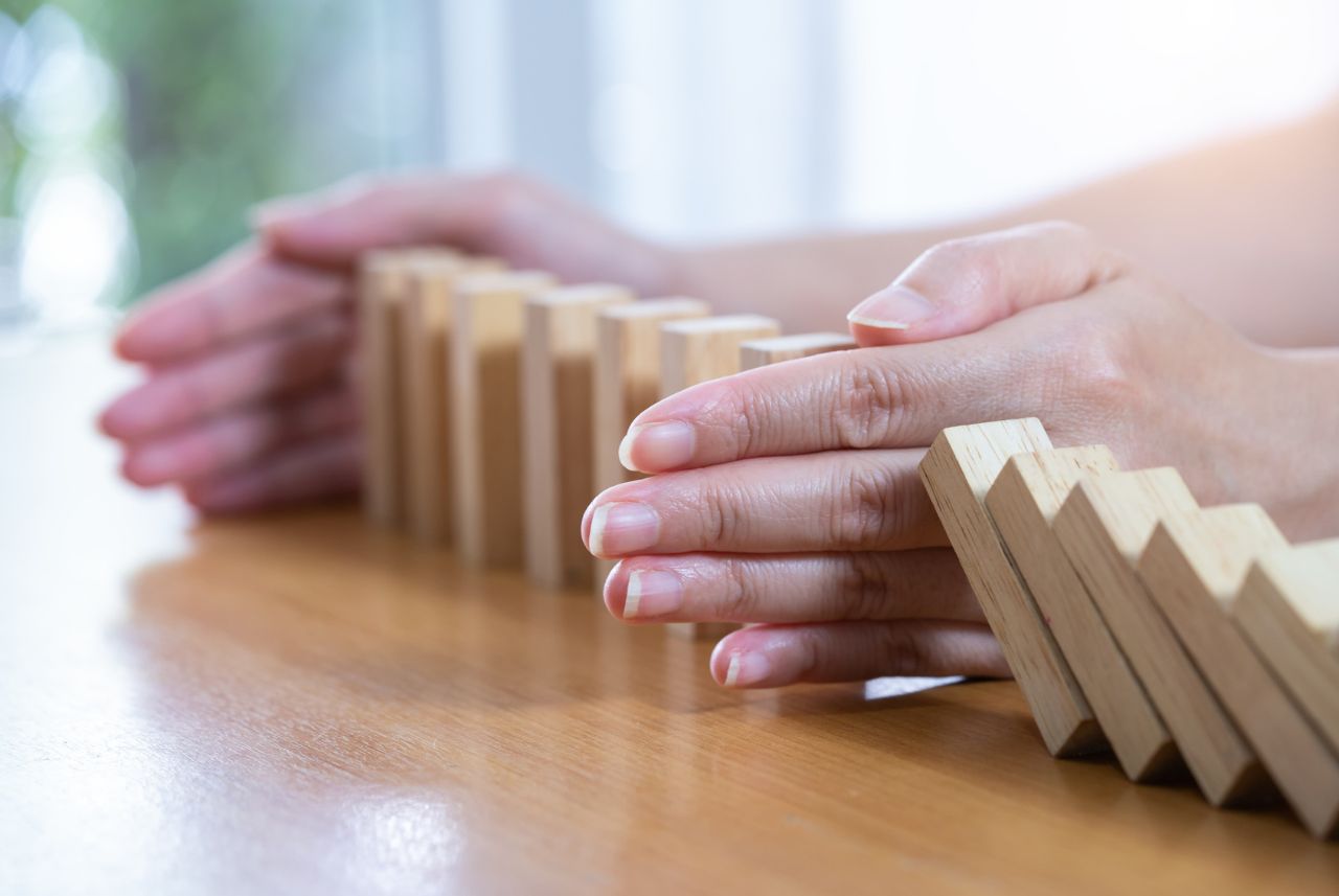 hands framing wood dominoes on table